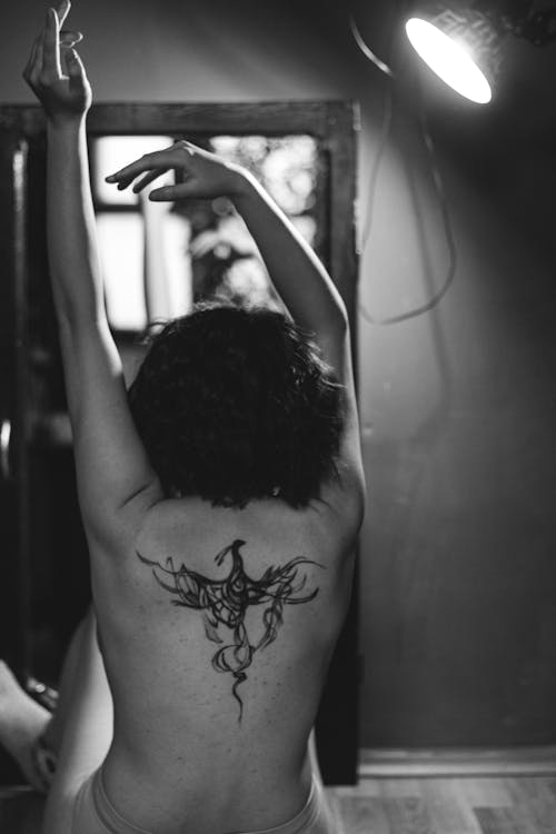Grayscale Photo of a Person with Tattoo on Her Back