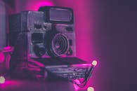 粉色霓虹灯环绕的复古宝丽来相机特写，捕捉着复古的气息