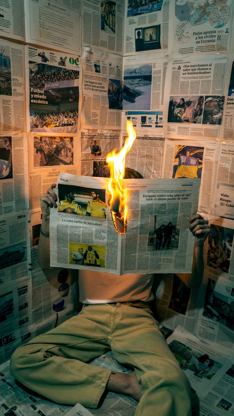 Person Holding A Burning Newspaper