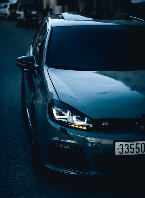 Free Low-angle view of a stylish car with bright headlights in a dim environment, enhancing its sleek design. Stock Photo