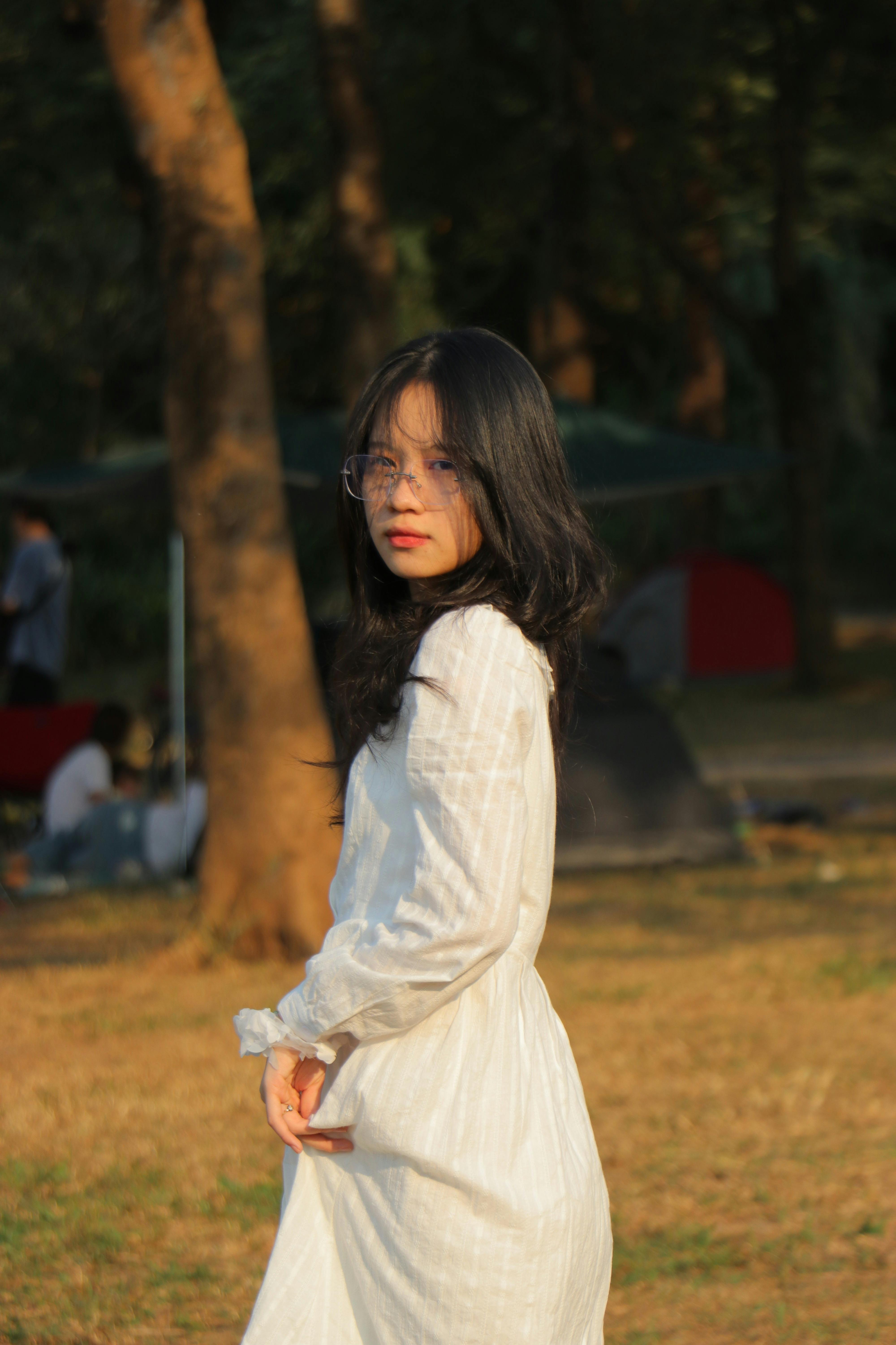 A Woman Taking Off Her Shirt on the Grass Field · Free Stock Photo