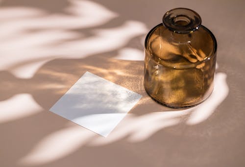 Brown Glass Bottle and a Blank Sticky Note