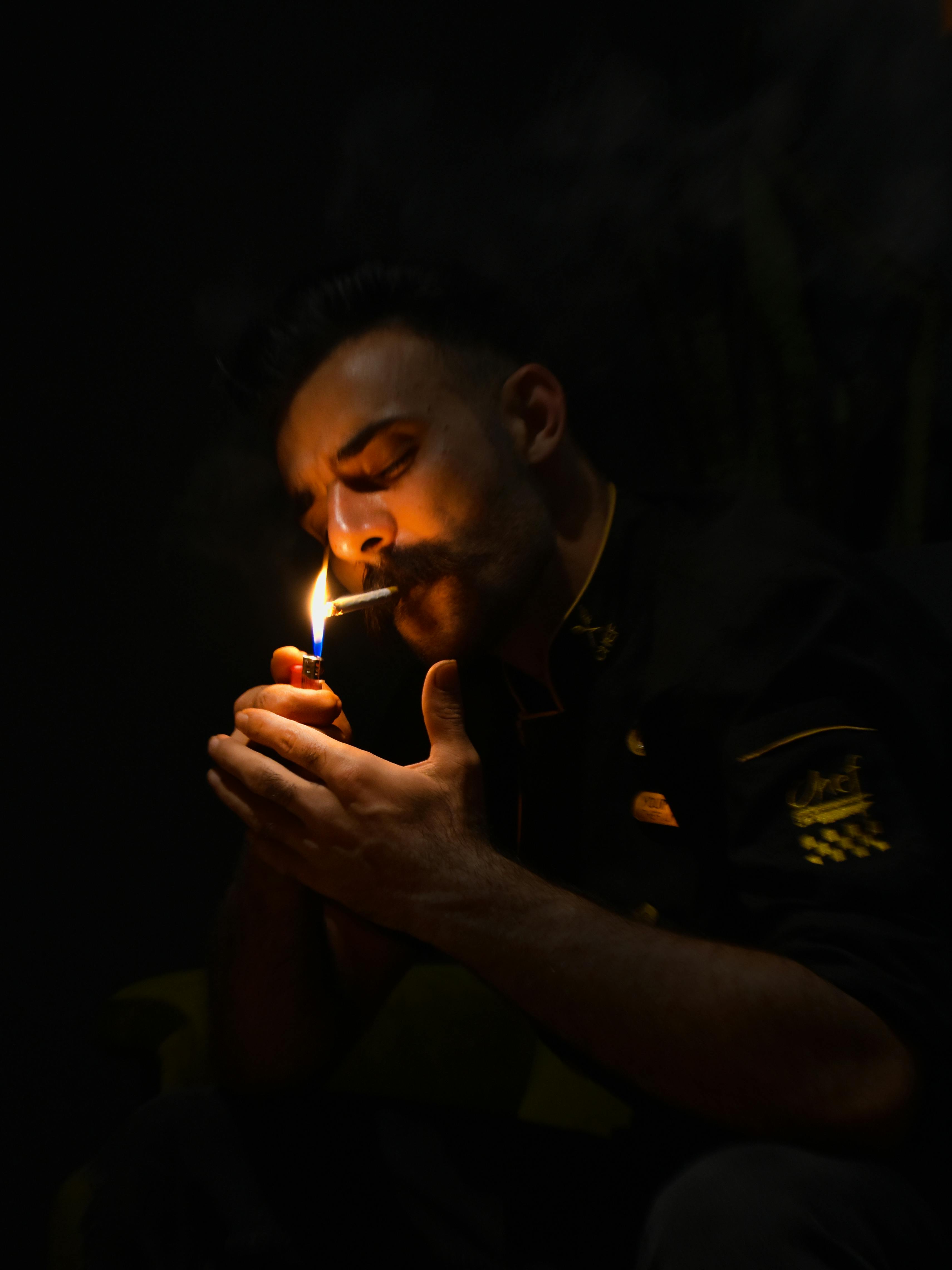 Man Holding a Lighter while Lighting His Cigarette · Free Stock Photo