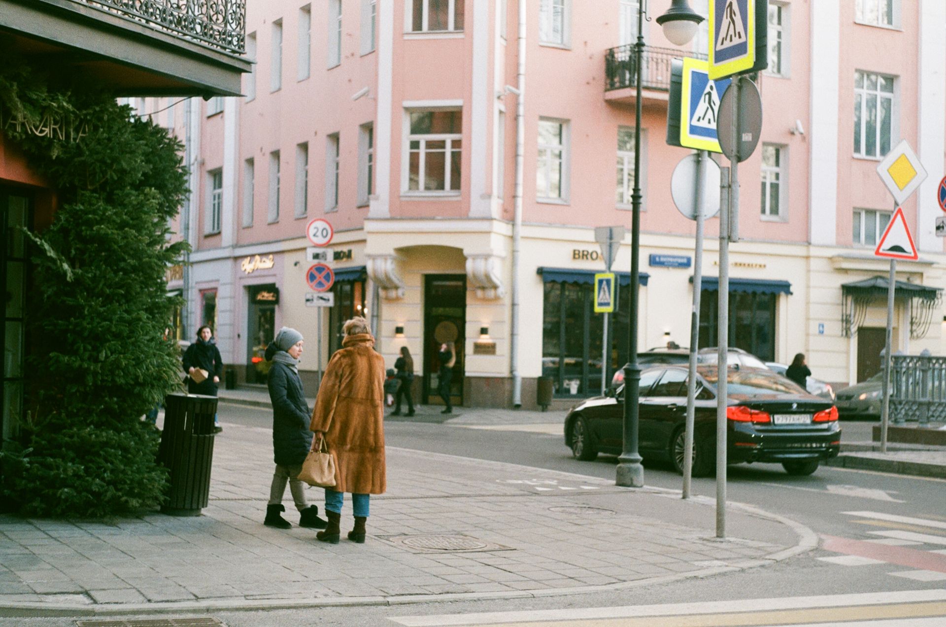 People Standing on the Side of the Road Near the Caution Signs