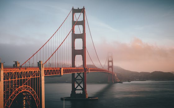 Golden Gate Bridge shrouded in fog during sunset, San Francisco. by Tae Fuller