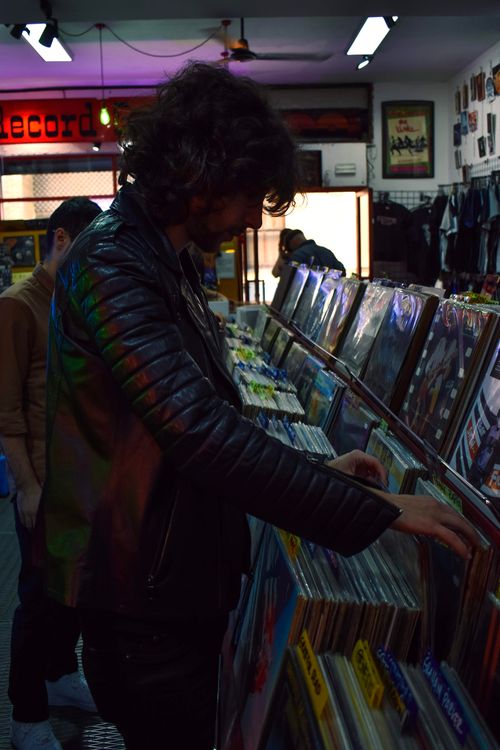 Free A man browsing vinyl records in a Sevilla record shop, wearing a black jacket. Stock Photo