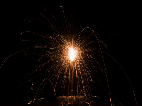 A captivating close-up of golden sparks from a fireworks display illuminating the dark night sky.