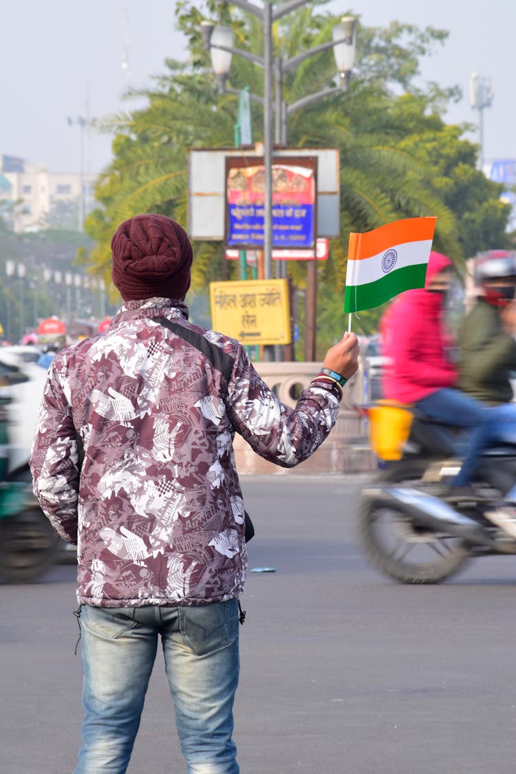 Person Waving A Flag On The Street