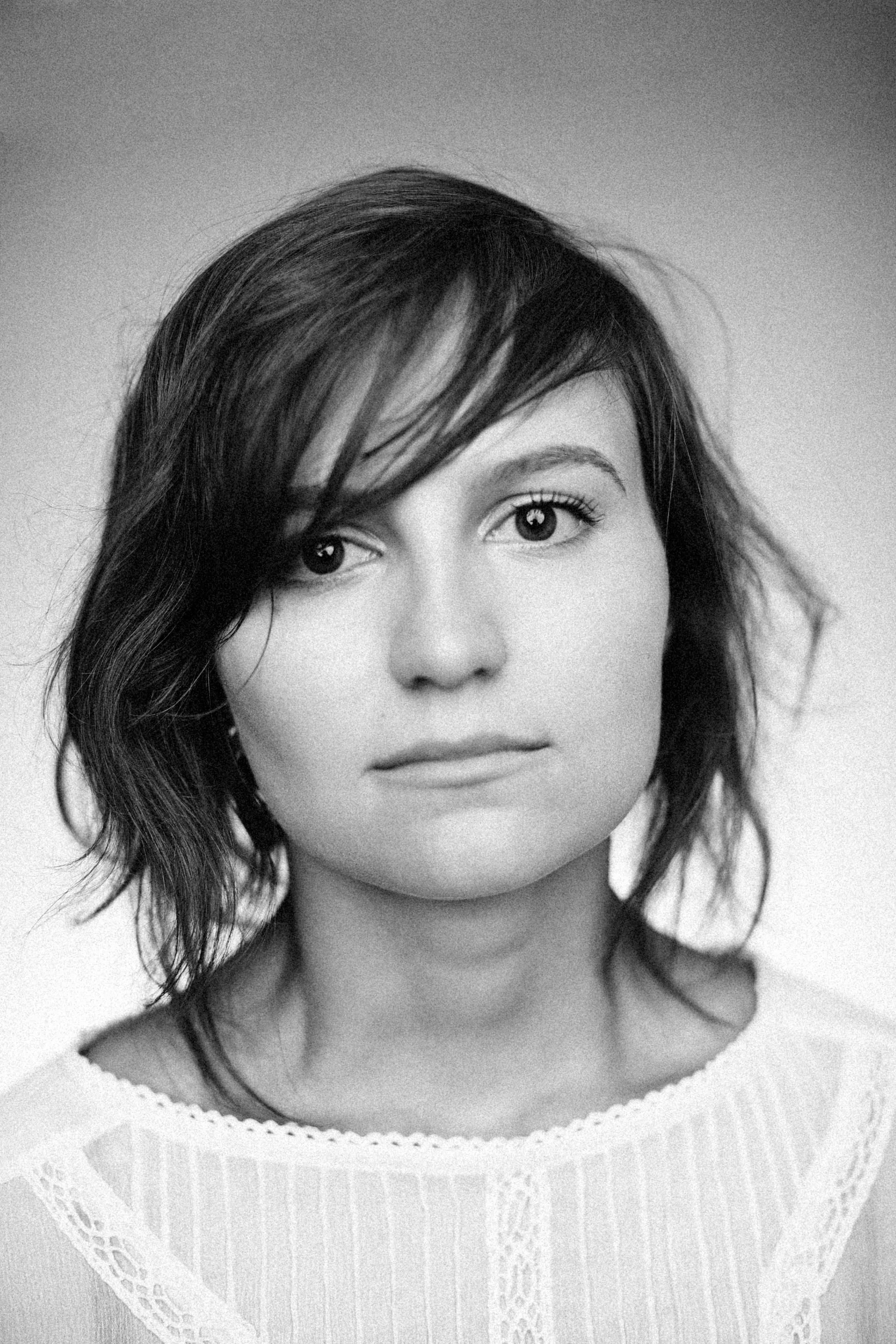 Black and white portrait of a woman with short hair, serene expression, studio setting.