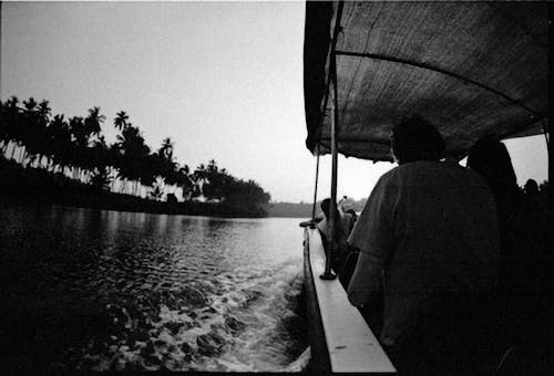 Black and White Photo of  People Riding a Boat