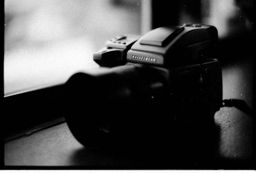 Black and white photo of a vintage Hasselblad camera on a table.
