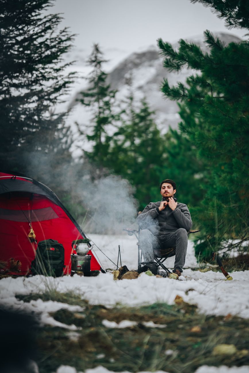 Camper settled beside a snowy winter camp, which is exactly when insulation numbers stop being nerd trivia and start mattering
