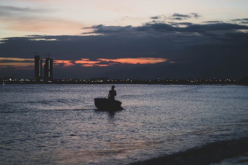 Free Silhouette of a Person on the Boat during Sunset Stock Photo