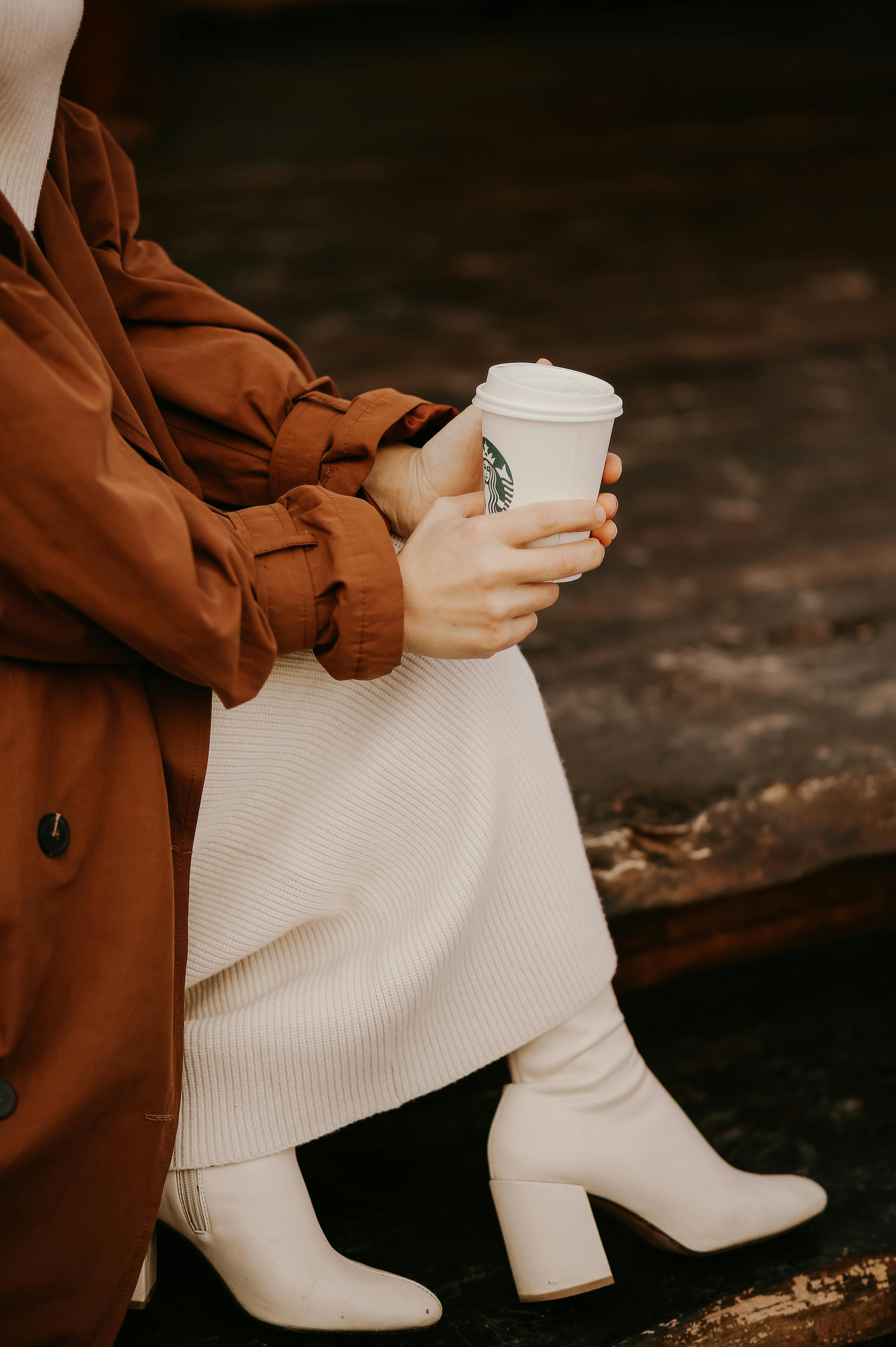 woman sitting and holding starbucks cup