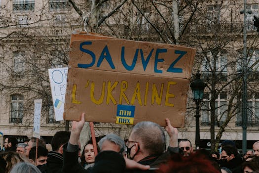 Group of people rallying with signs in support of Ukraine on a city street.