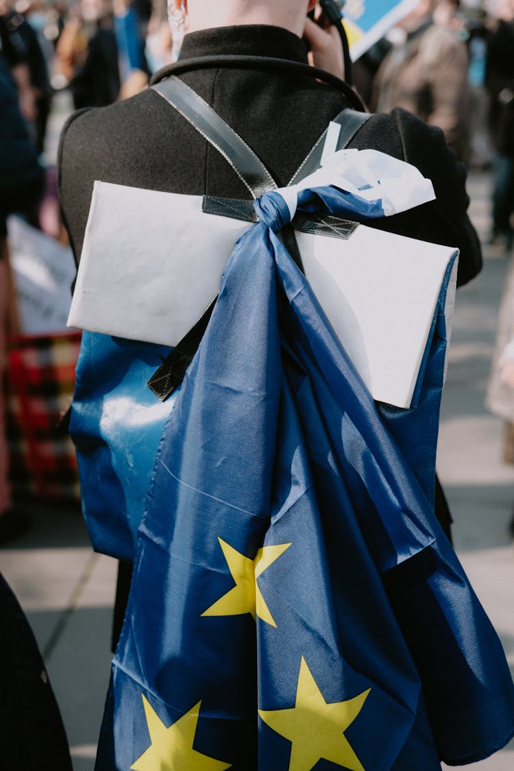 Person With Flag Tied On Backpack