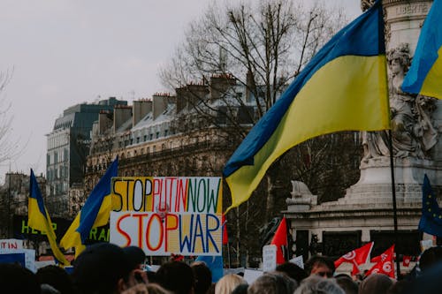 A Sign Board on Street with Group of People