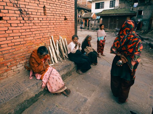 A Group of People Sitting on Side of the Street