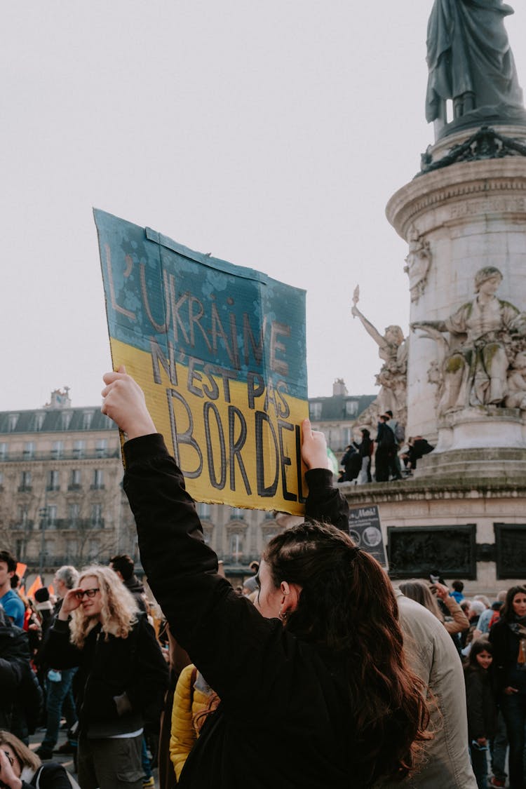 Woman Holding Up A Poster 