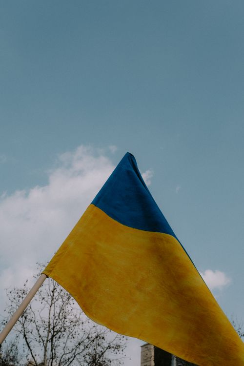 Free Vibrant Ukrainian flag waving against a clear blue sky, symbolizing patriotism and unity. Stock Photo
