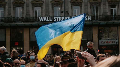 Free Blue and yellow Ukrainian Flag Waving Above Crowd of People Stock Photo