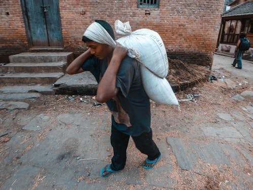 Man Carrying a Heavy Sack