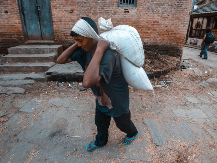 Man Carrying A Heavy Sack