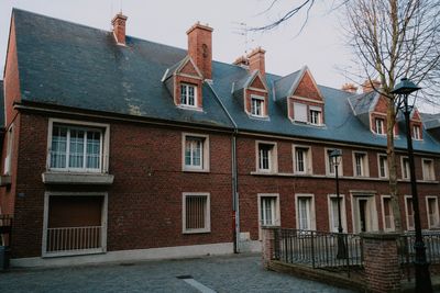 Classic brick building with dormer windows, by Mathias Reding on Pexels