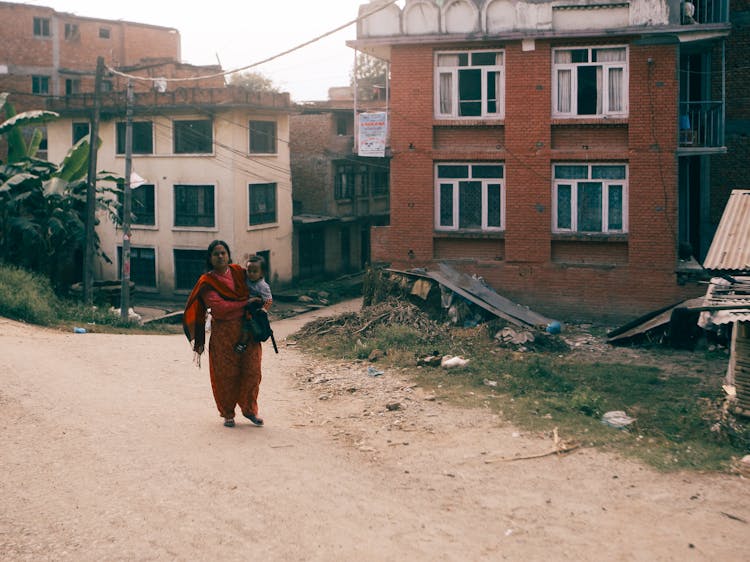 A Woman Carrying A Baby Boy