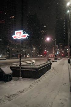 A snowy night in Toronto featuring a TTC subway sign and city lights in winter.
