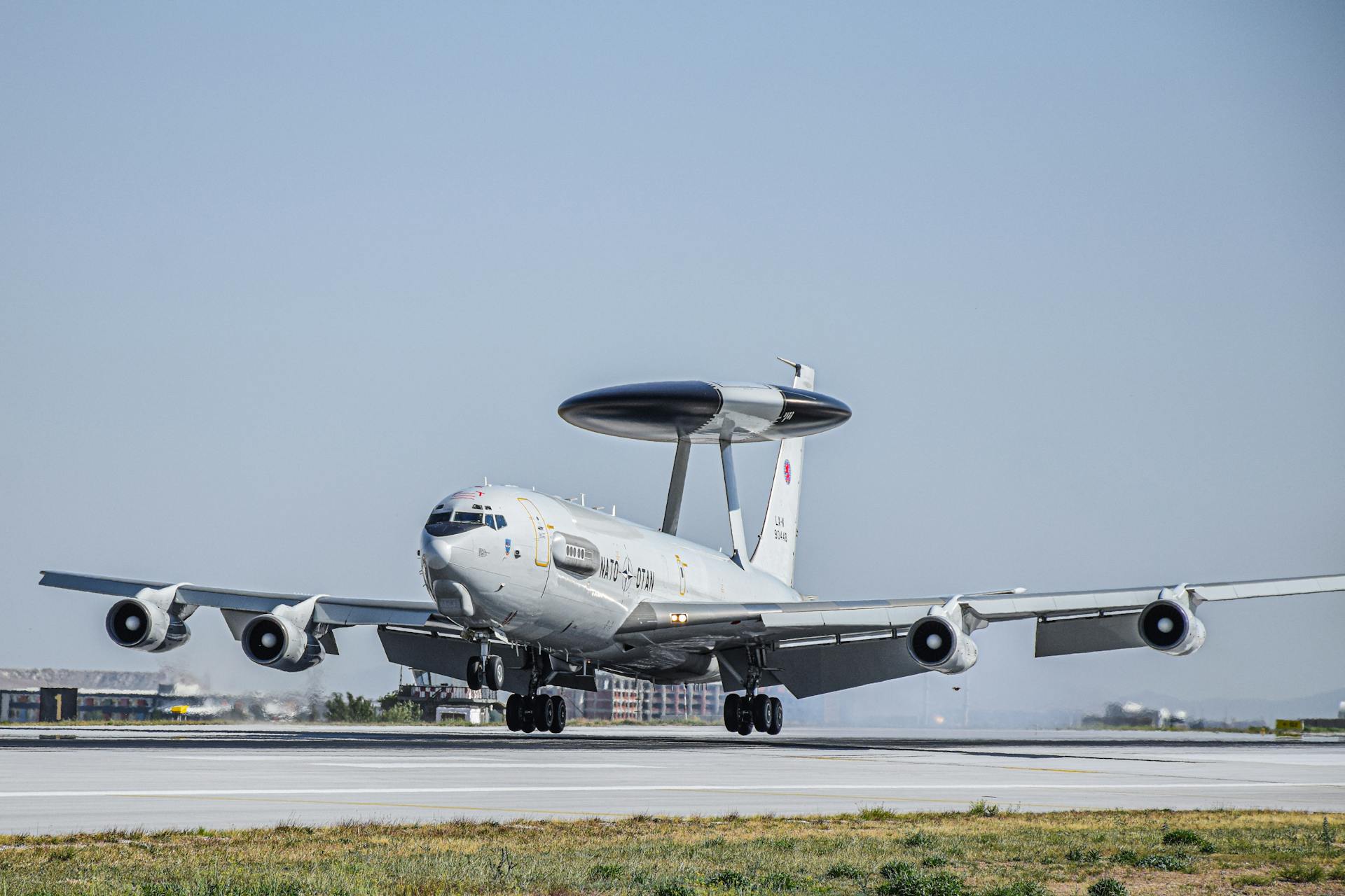 NATO AWACS aircraft preparing for takeoff on sunlit runway, showcasing its advanced surveillance capabilities.