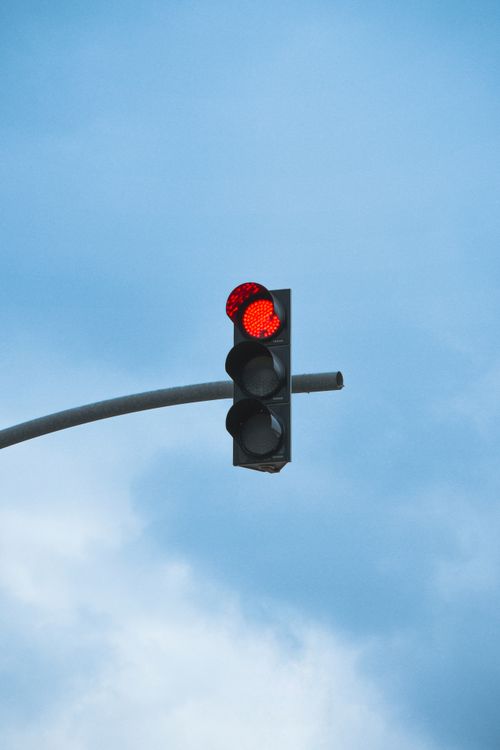 Free Traffic light displaying red light against a clear blue sky backdrop. Stock Photo