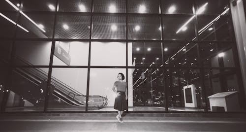 Free Grayscale Photo of a Woman outside a Building Stock Photo