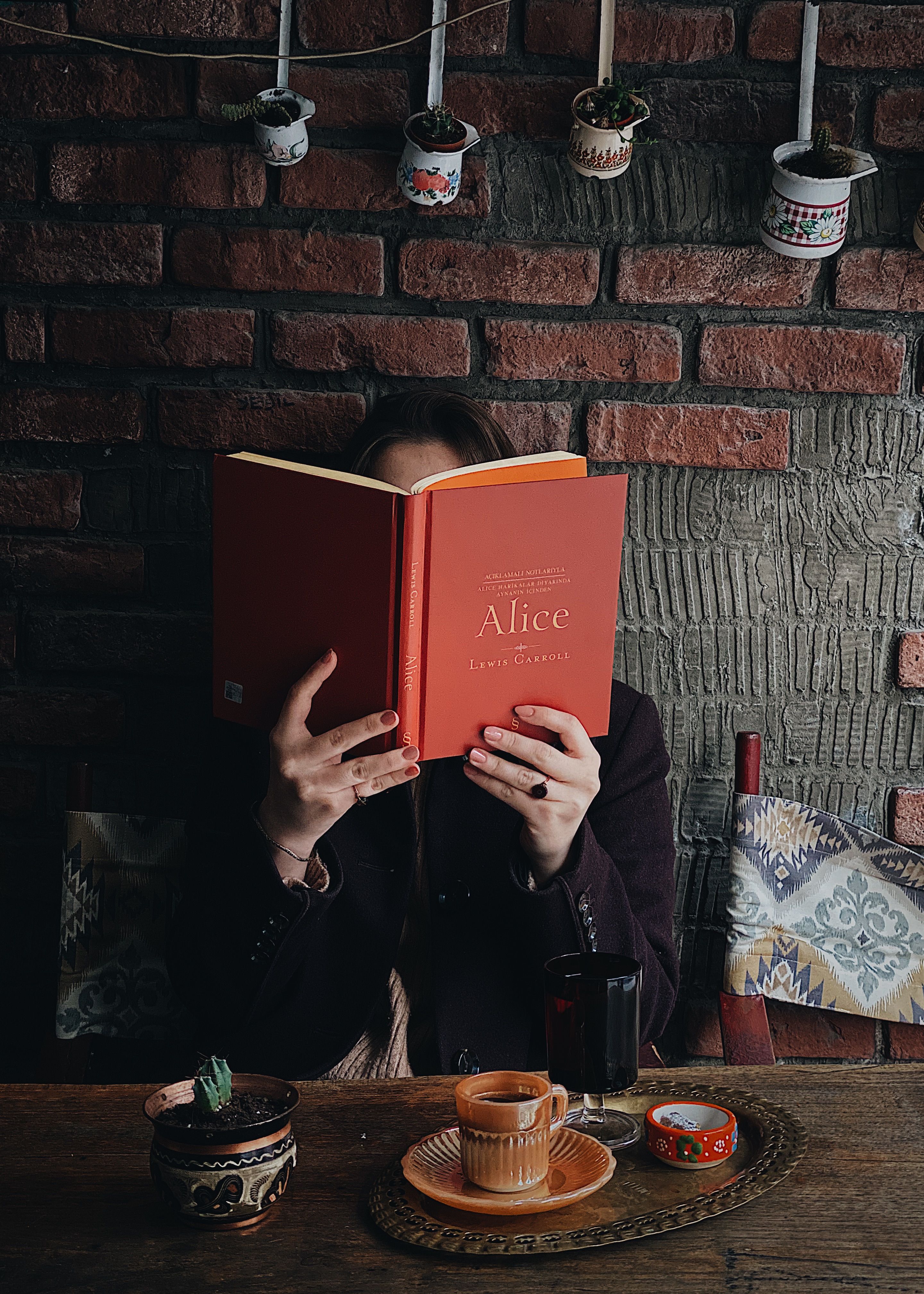 A woman reading a book in a cozy café setting in Istanbul, Turkey. Warm and inviting atmosphere.