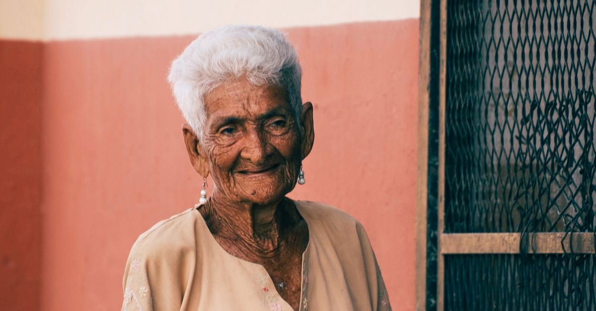 elderly person smiling outdoors in sunlight representing healthy aging