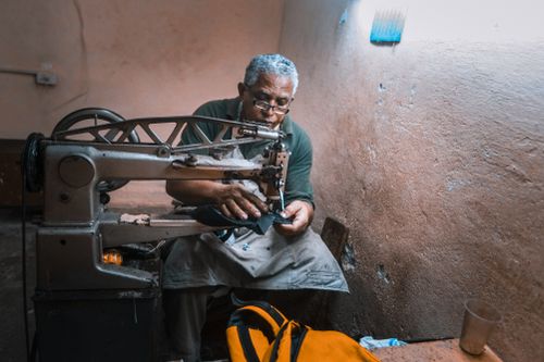 Free An experienced tailor crafting with precision at an old sewing machine in a workshop. Stock Photo
