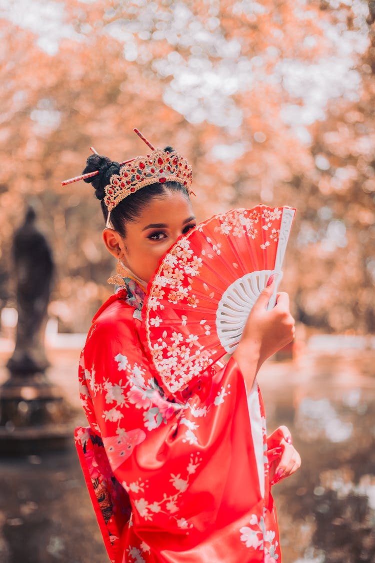 Woman Covering Face With A Red Fan