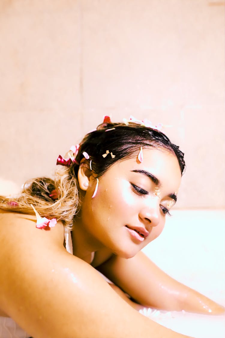 Woman With Petals On Head In Bath