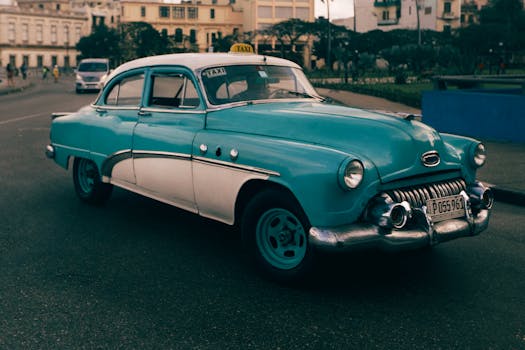 A classic turquoise taxi car cruising down an urban street, showcasing retro style.