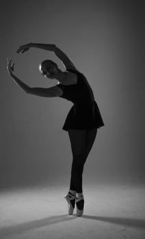 Graceful ballerina posed in a classic ballet position, captured in monochrome.