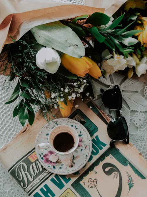 Bouquet of Flowers Lying Next to Cup of Coffee