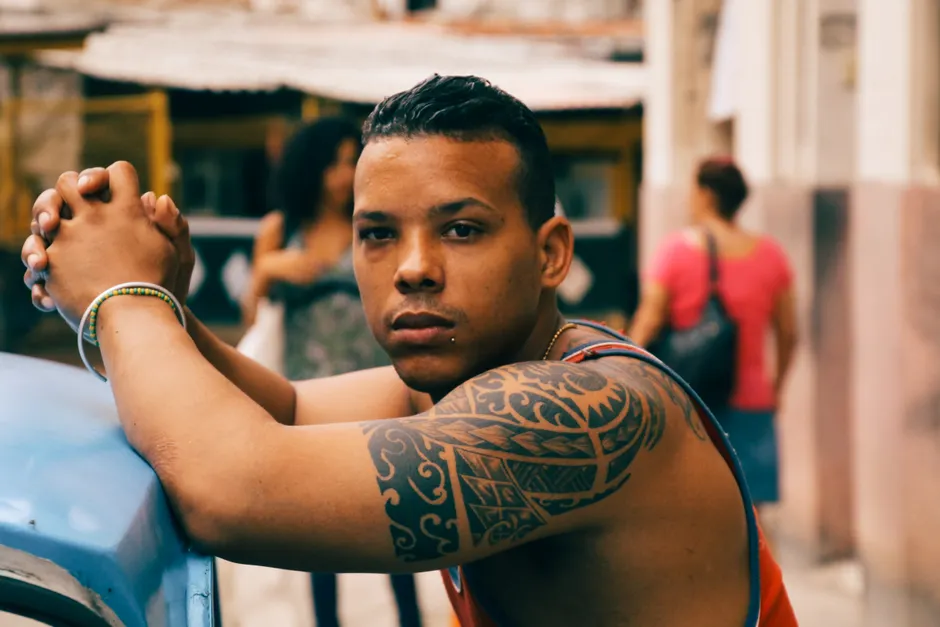 Man showing off a bold black tribal temporary tattoo sleeve on his shoulder and arm