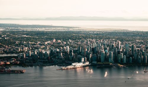 Free Scenic aerial shot of Vancouver's skyline with waterfront and mountains in the background. Stock Photo