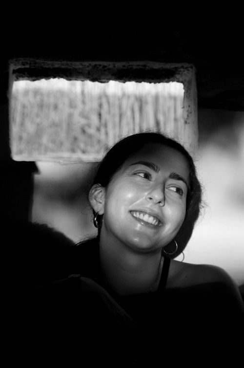 Free Black and white portrait of a smiling woman in dramatic lighting, showcasing her expression and mood. Stock Photo