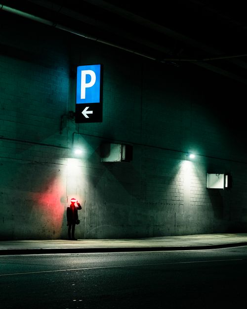Free A person stands under neon lights by a concrete wall in Vancouver, BC, with a futuristic feel. Stock Photo
