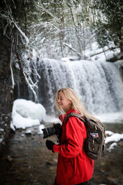 Young Smiling Female Photographer in Red Jacket in Winter Scenery