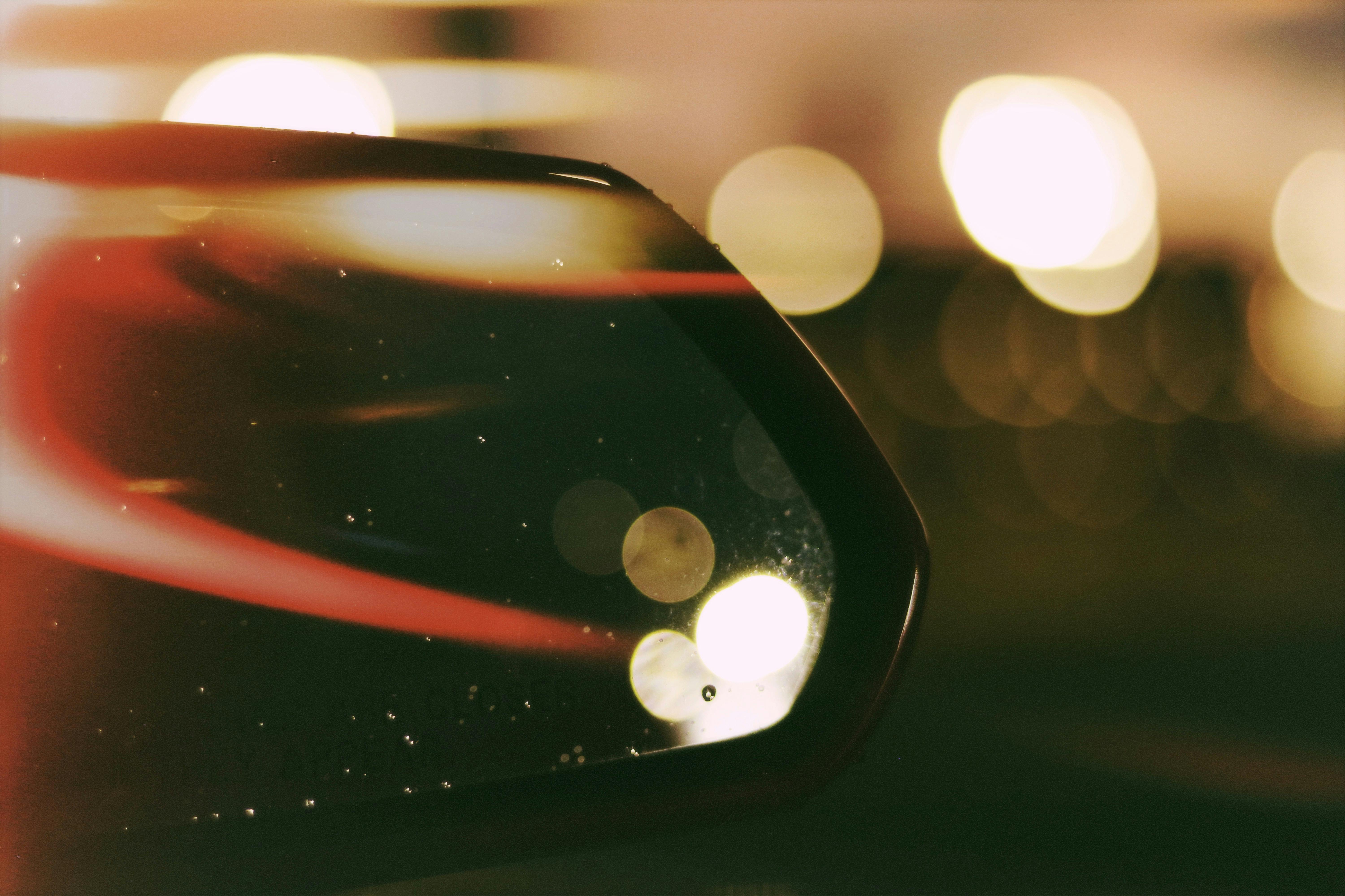 Artistic bokeh effect on car side mirror creates a dreamy night scene.