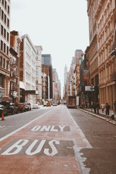 Urban scene of a busy New York City street with buildings and traffic during the day.