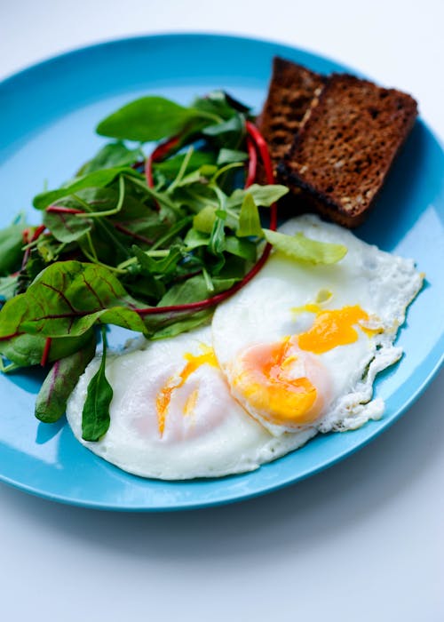 Free Eggs, Greens and Toast on Blue Plate Stock Photo