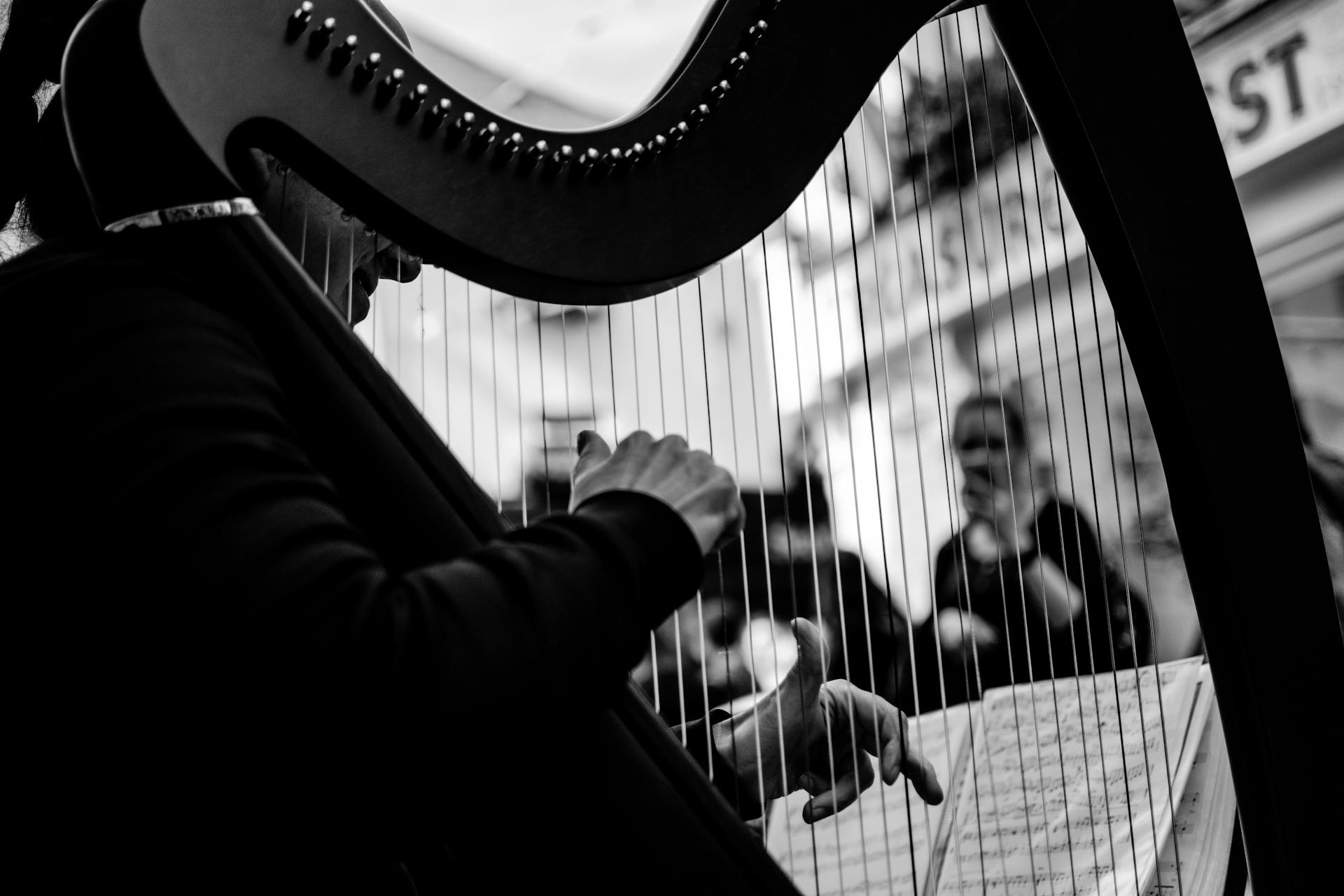 A captivating black and white photo of a harpist performing outdoors in Galway.